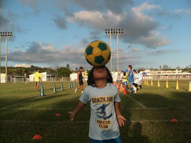 BSC camper balancing a soccer ball under an open sky in Okinawa