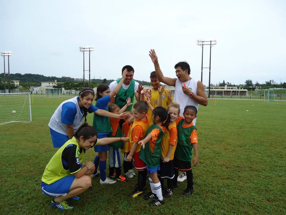 BSC campers and coaches celebrating together on the field in Okinawa
