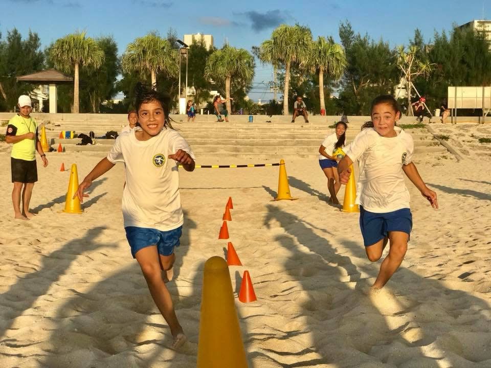 BSC campers running together through cones on the beach in Okinawa