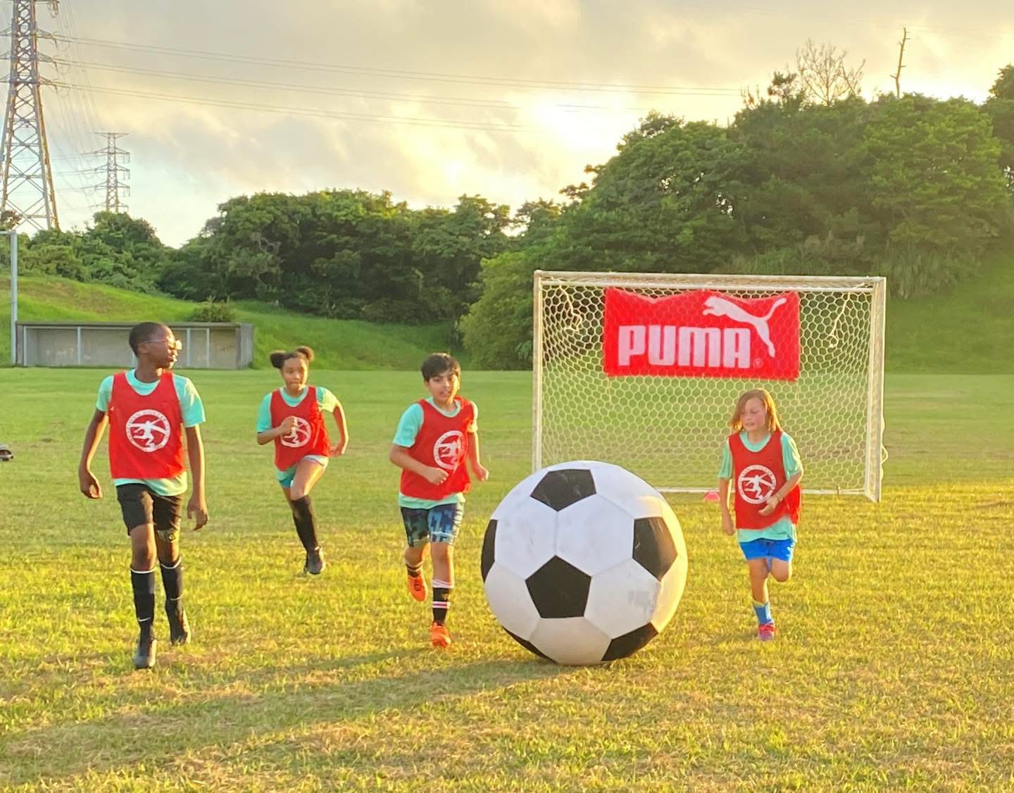 BSC Summer Camp 2021 — campers running with a giant inflatable soccer ball on the field